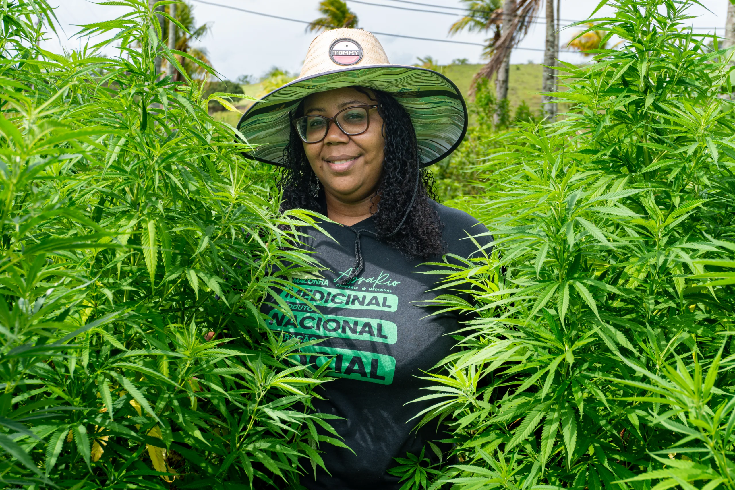 Fotografia de Marilene Esperança, uma mulher negra, com dois pés de maconha