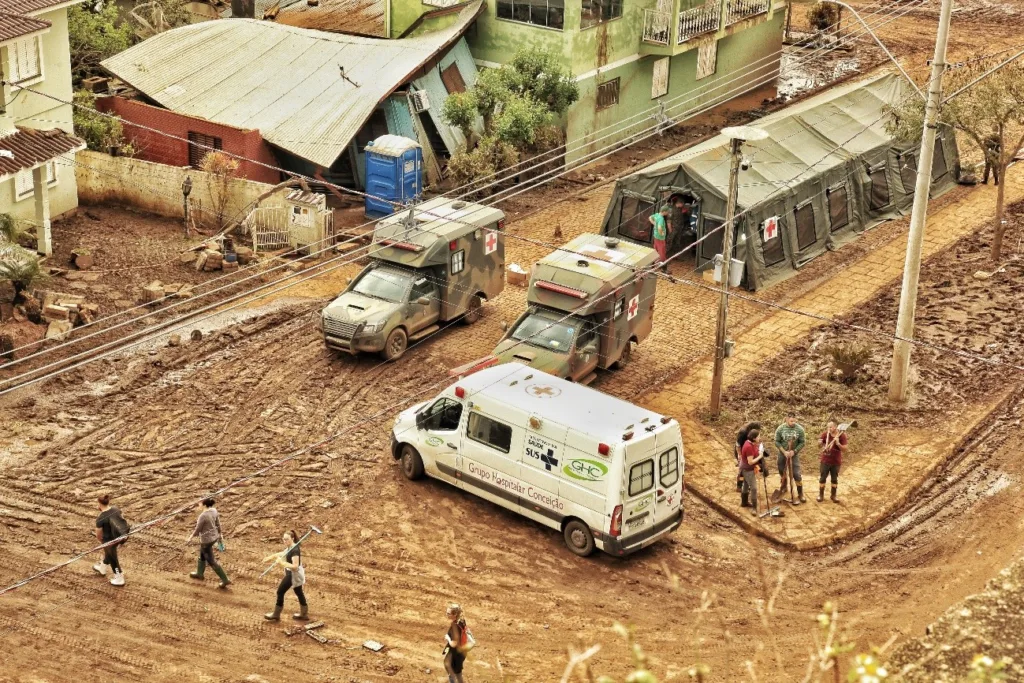 Ambulâncias e estruturas de campanha simbolizam a pronta-resposta do Estado por meio da Força Nacional do SUS, que projeta novas bases regionais para alcançar áreas afetadas em até 12 horas