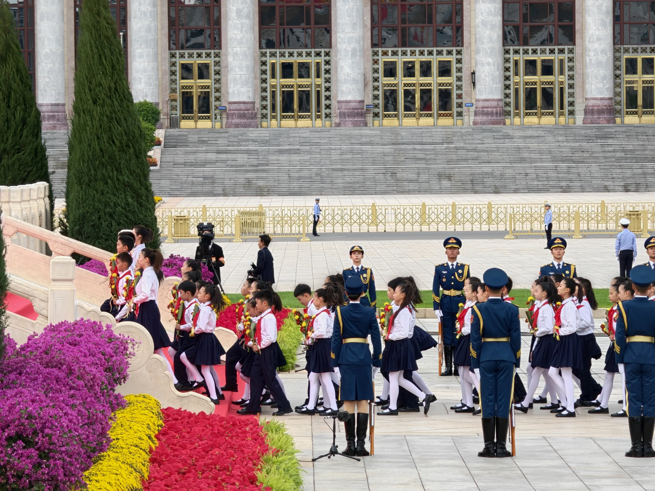 Jovens Pioneiros, uma organização de massa de crianças chinesas, que, segundo definição oficial, serve com força de reserva para a força de reserva "para a causa do socialismo e do comunismo e para o rejuvenescimento nacional", levam flores amarelas ao Memorial dos Heróis do Povo, na Praça Tiananmen, em Pequim - 30 de setembro de 2026