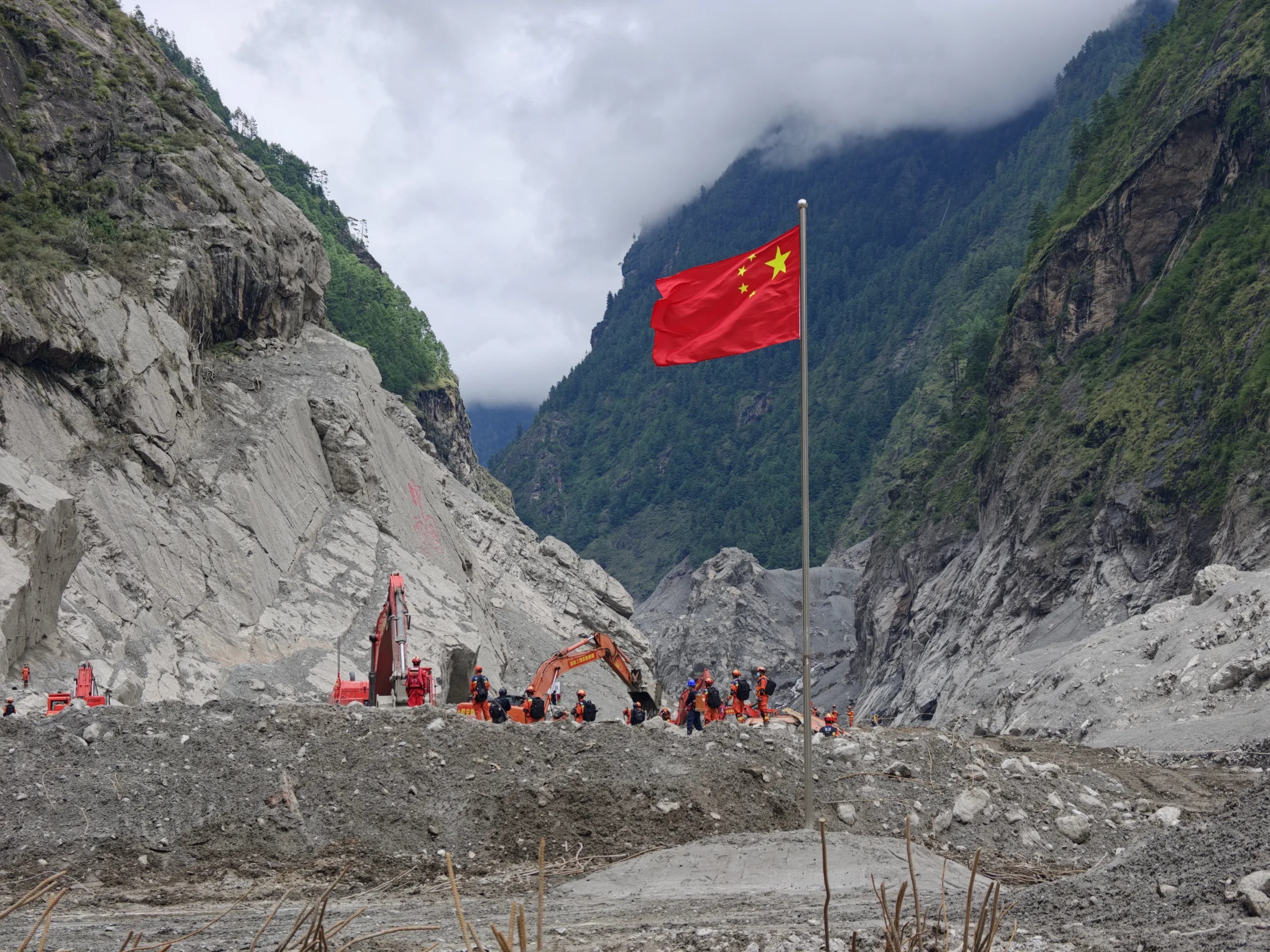 Bandeira da China no lugar onde estava a aduana de Gyirong (Jilong), na fronteira com o Nepal. O prédio da aduana e a Ponte da Amizade Sino-Nepalesa que conectava os dois países foram completamente destruídas. 30 de abril de 2023