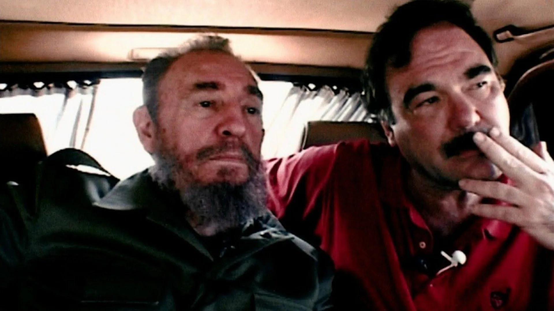 Na parte traseira de um carro, Fidel Castro está ao lado do diretor Oliver Stone