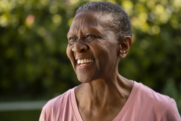 Mulher negra é fotografa de perfil em parque