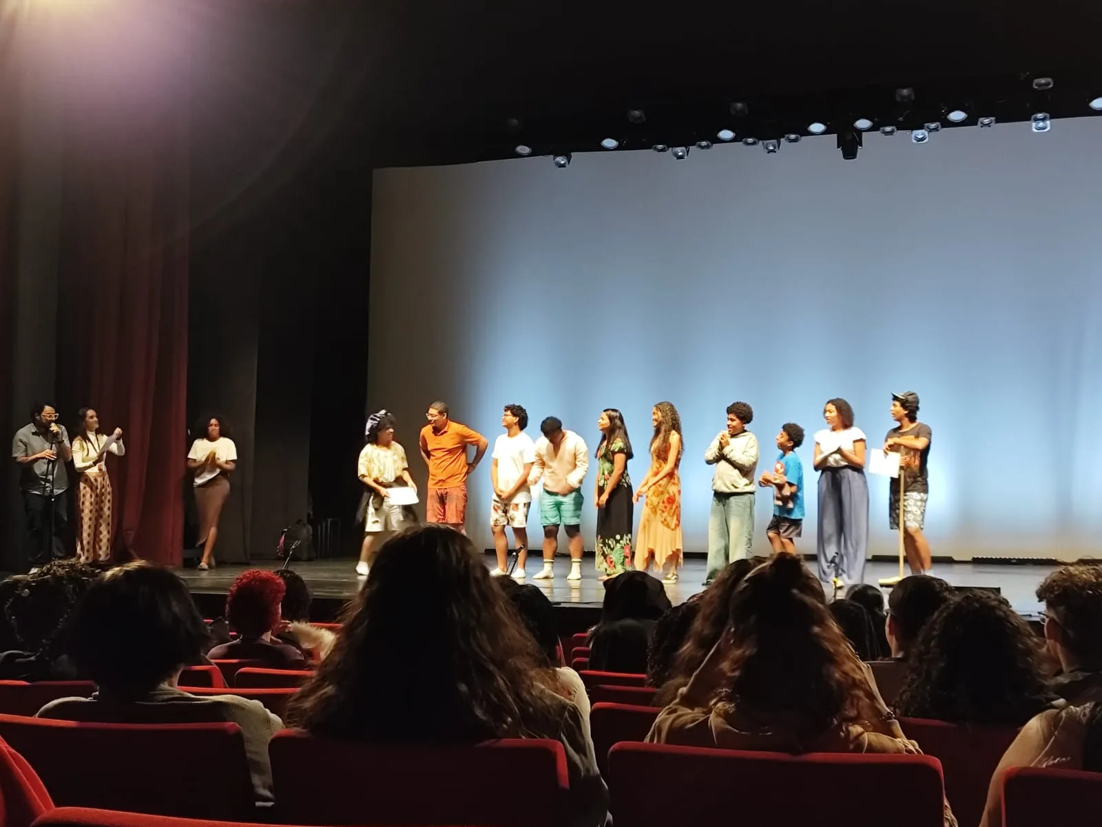 Grupo de estudantes recebe aplausos da plateia após apresentação