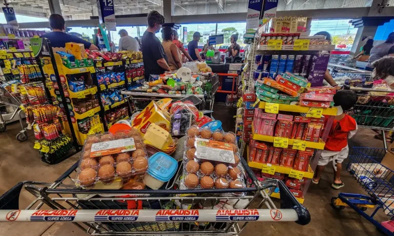 Carrinho cheio de compras de alimentos em supermercado.