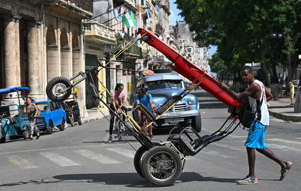 Um homem empurra um bici-táxi por uma rua de Havana, em 7 de setembro de 2026.