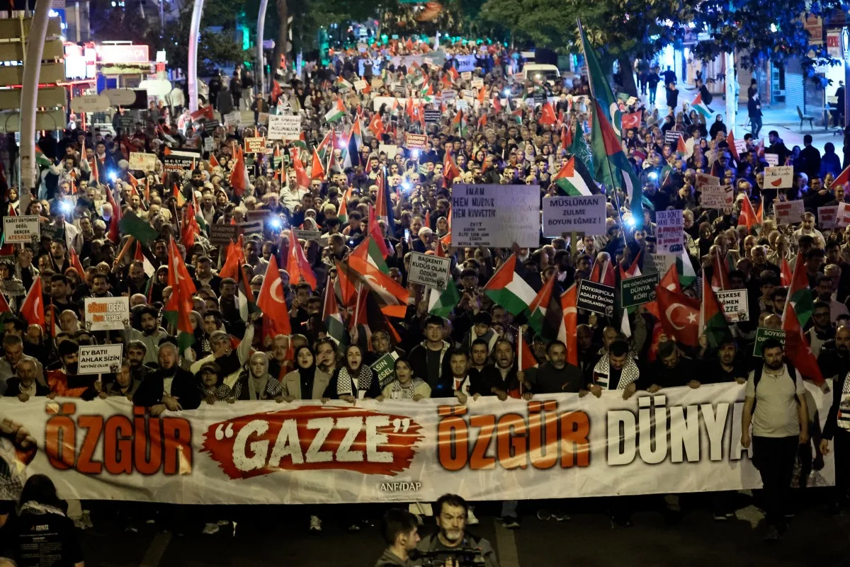Protestantes seguram um banner com o texto "Liberte Gaza, liberte o mundo" enquanto marcham em ato pró-Palestina. 07/10/2026