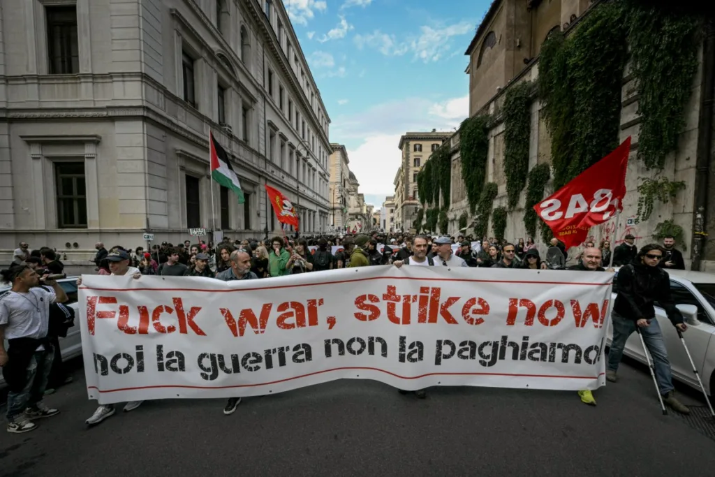 Manifestantes em Roma exibem cartaz com o texto "nós não vamos pagar pela guerra". O protesto exige mais gastos sociais e fim da política de rearmamento. 30/10/2027.
