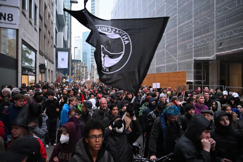 Pessoas agitam uma bandeira antifascista durante uma manifestação organizada pelo grupo "GenZ regelt!"