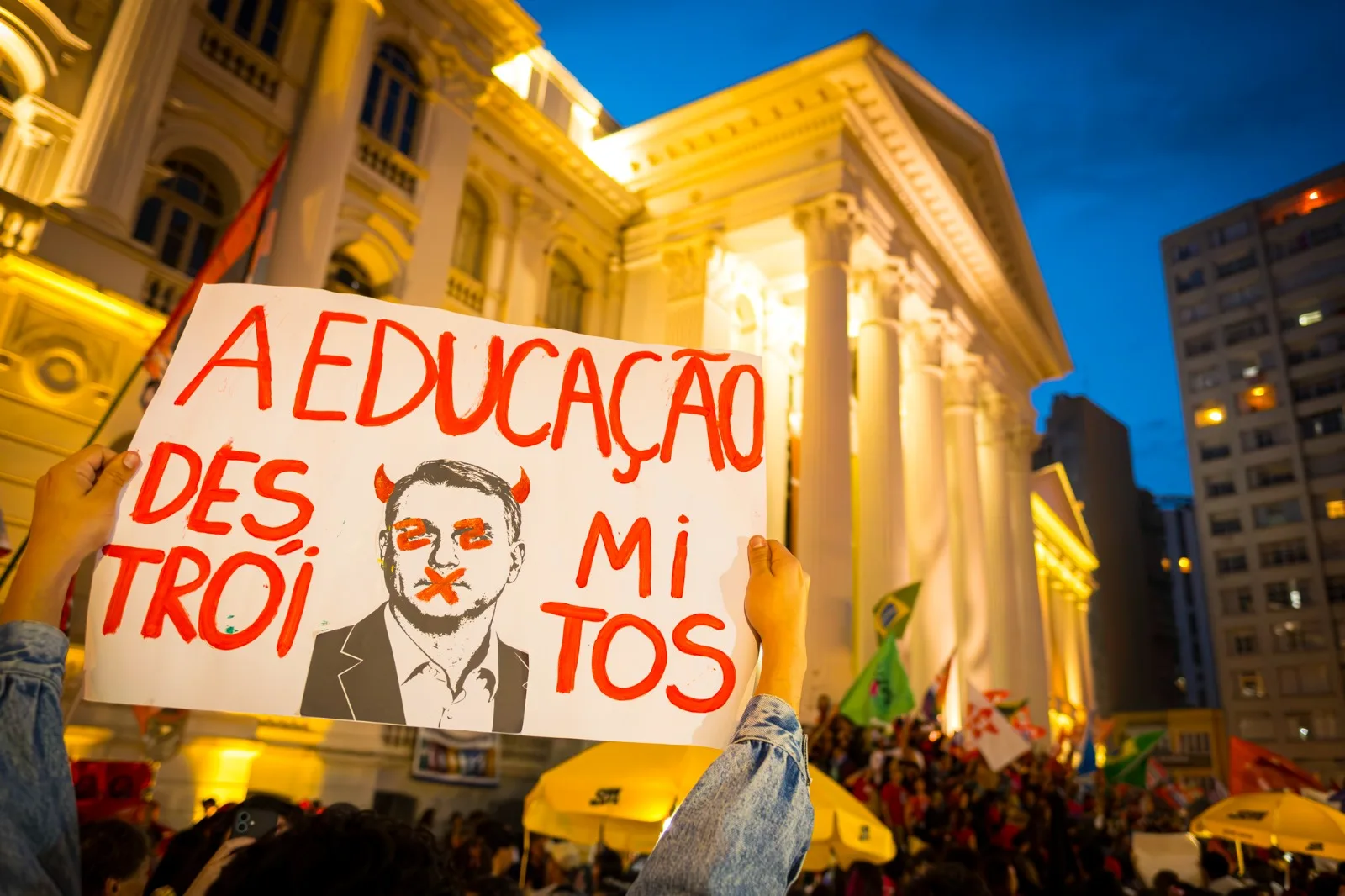 Ato com cartaz 'A Educação destrói mitos' em frente ao prédio histórico da UFPR