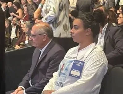 Cristiane Gomes da Silva, mãe de Ana Clara, ao lado do vice-presidente Geraldo Alckmin, na plateia do debate da Globo entre Lula e Flávio