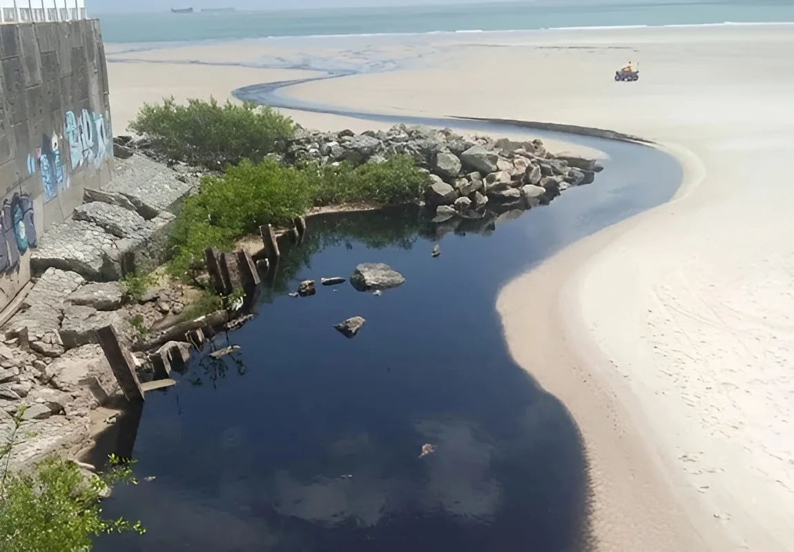 Fotografia mostra o esgoto chegando à praia.