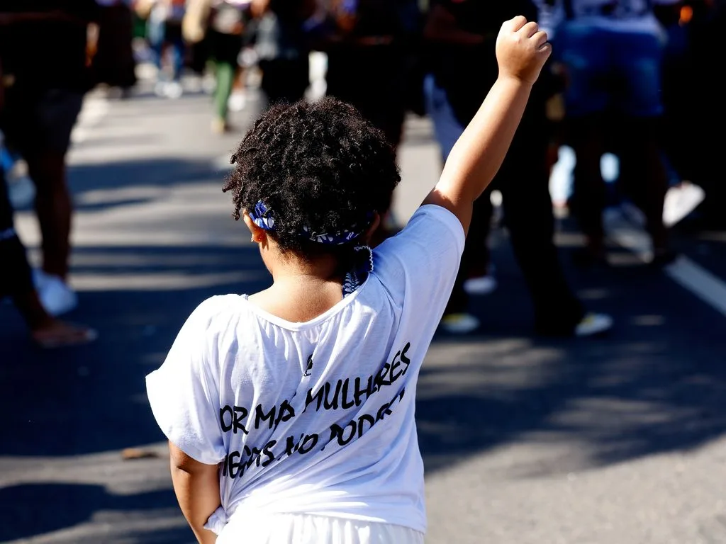 Criança participa da edição de 2026 do Julho das Pretas em defesa da democracia, do combate ao racismo, da reparação e do bem viver realizada na orla da Praia de Copacabana, zona sul do Rio