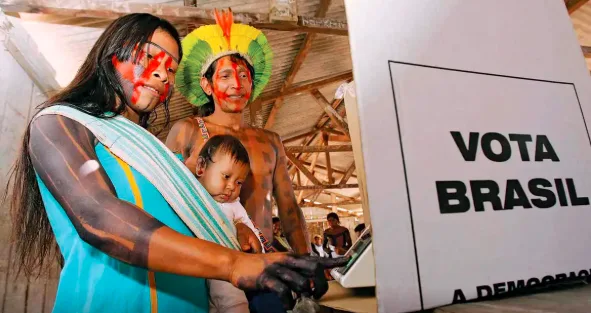 Indígena vota durante a eleição; em alguns locais, mães com bebês de colo foram impedidas de votar.
