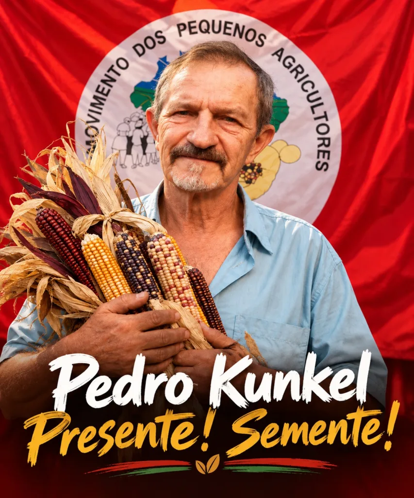 Pedro Kunkel em frente a badeira do Movimento dos pequenos agricultores