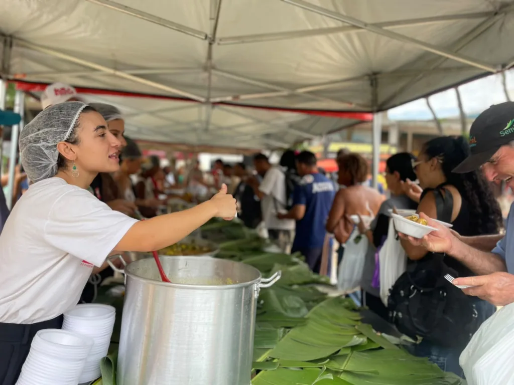 Voluntária serve refeição durante o Banquetaço, iniciativa que combina a distribuição de alimentos com a defesa de políticas públicas de combate à fome